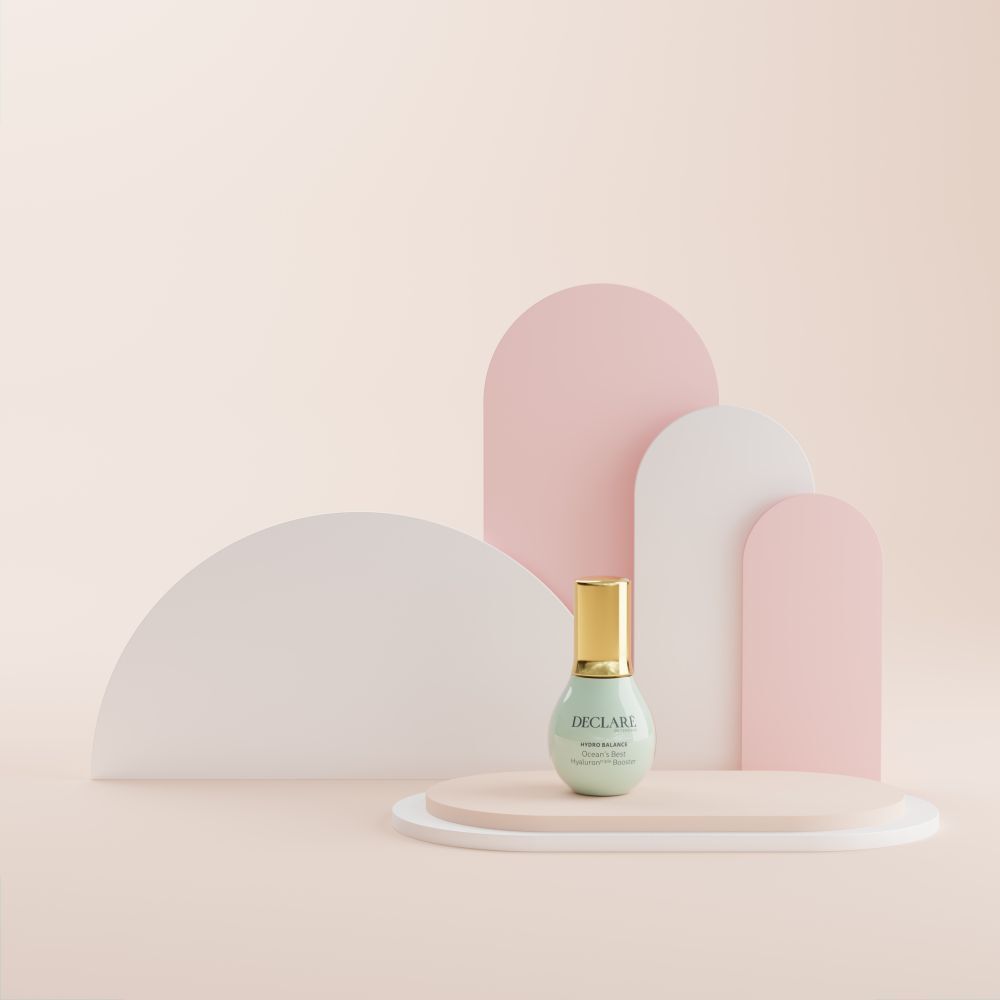 Flacone su un piedistallo. Sfondo: forme rosa, bianche e rosa. Scritta: DECLARÉ, Ocean's Best Hyaluron triple Booster.