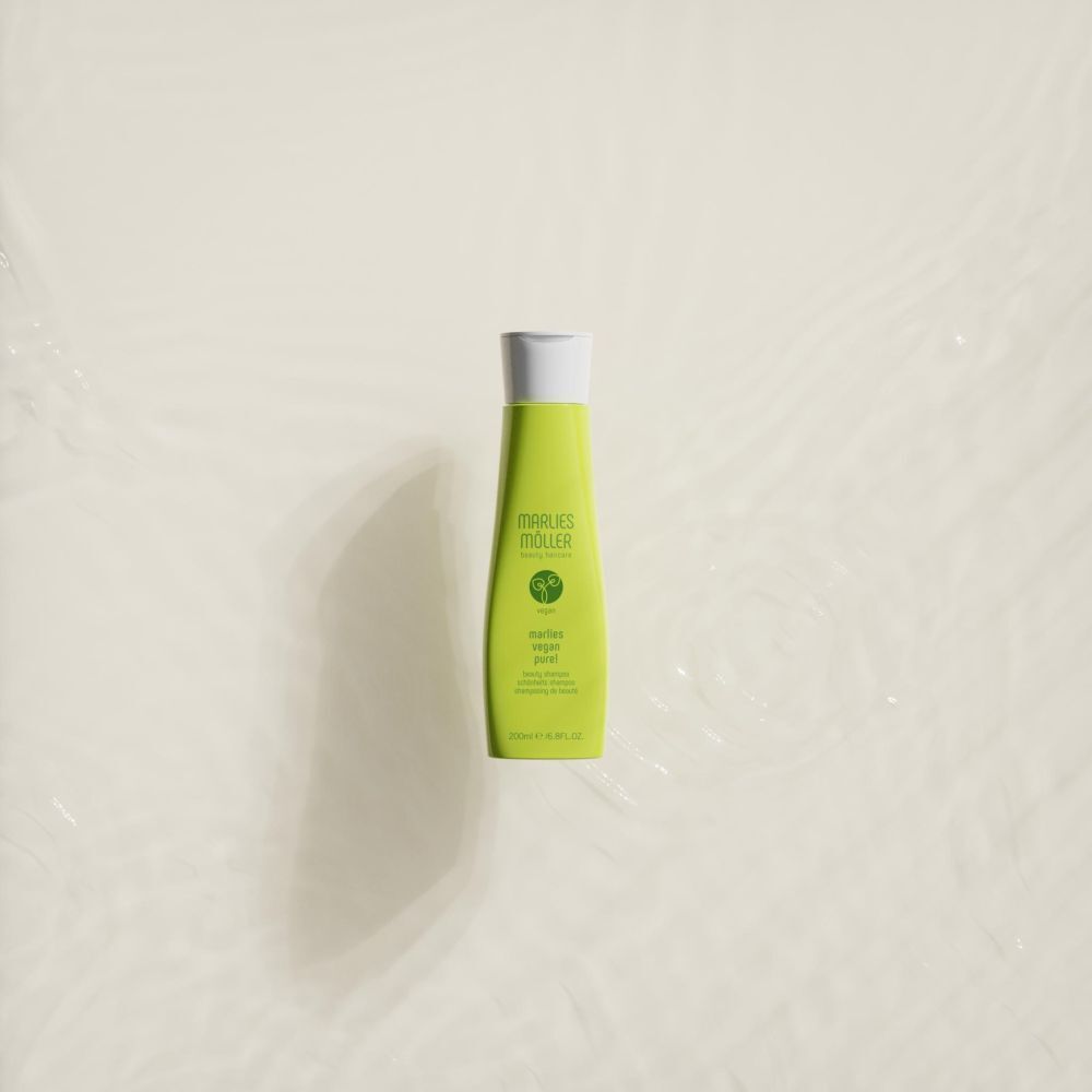 Flacone di shampoo verde nell'acqua. Scritta: Marlies Möller, Vegan Pure! Shampoo per capelli.