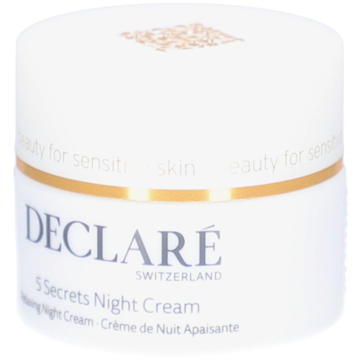Vasetto bianco con coperchio dorato. Scritta: DECLARÉ, 5 Secrets Night Cream. Testo: Relaxing Night Cream, Crème de Nuit Apaisante.