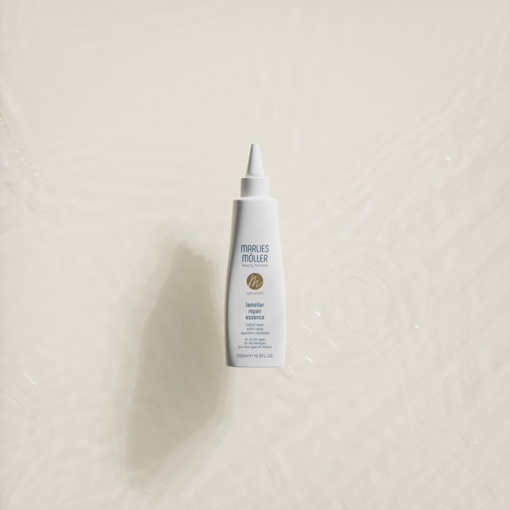 Flacone bianco con beccuccio, Marlies Möller, Lamellar Repair Essence, su sfondo chiaro. Vista dall'alto.