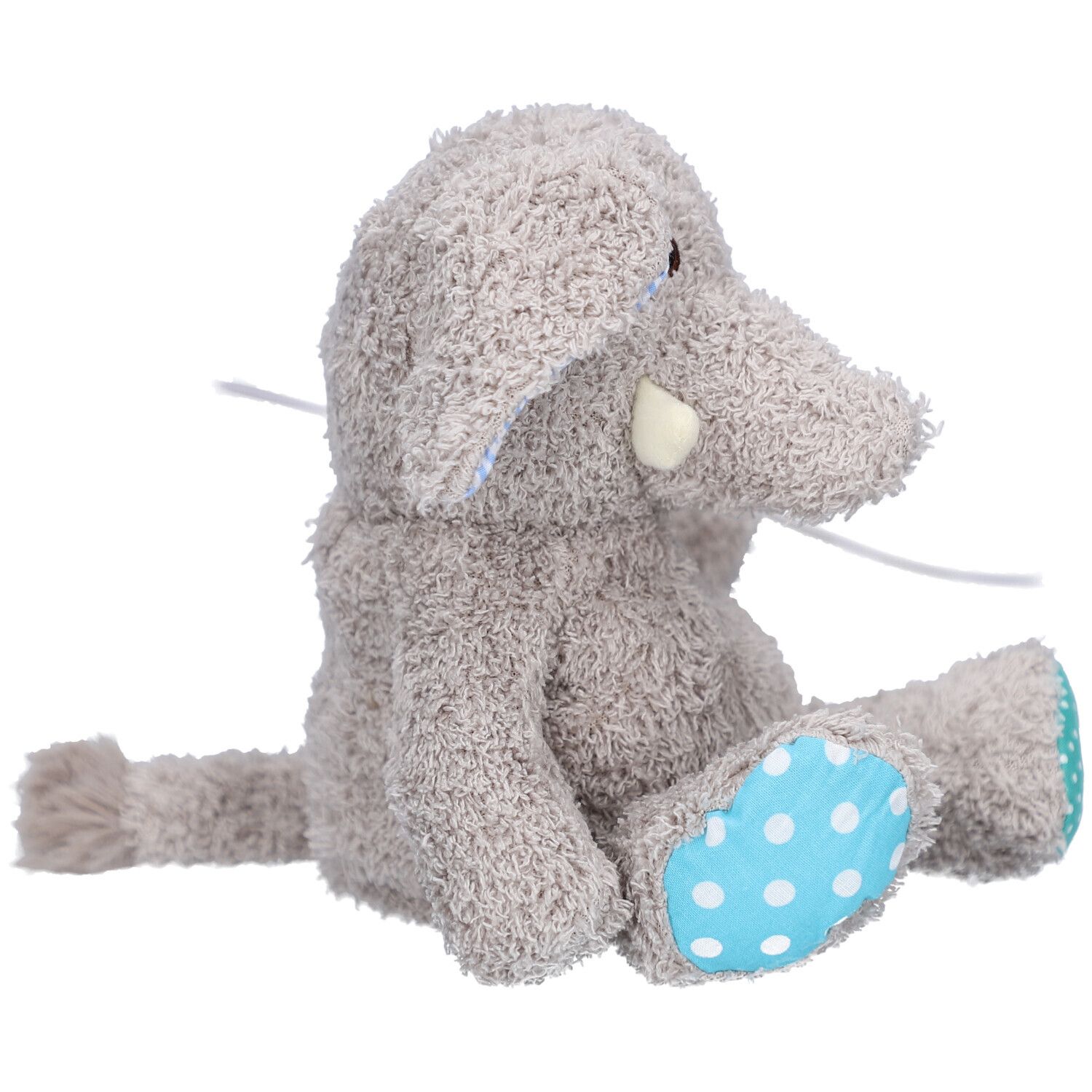 Elefante di peluche grigio seduto, con pois blu sui piedi. Zanna bianca visibile.