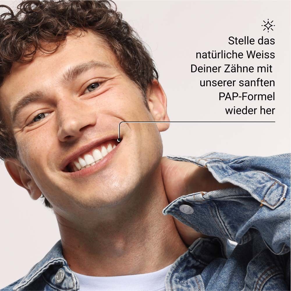 Uomo sorridente. Testo: Ripristina il bianco naturale dei tuoi denti con la nostra delicata formula PAP.