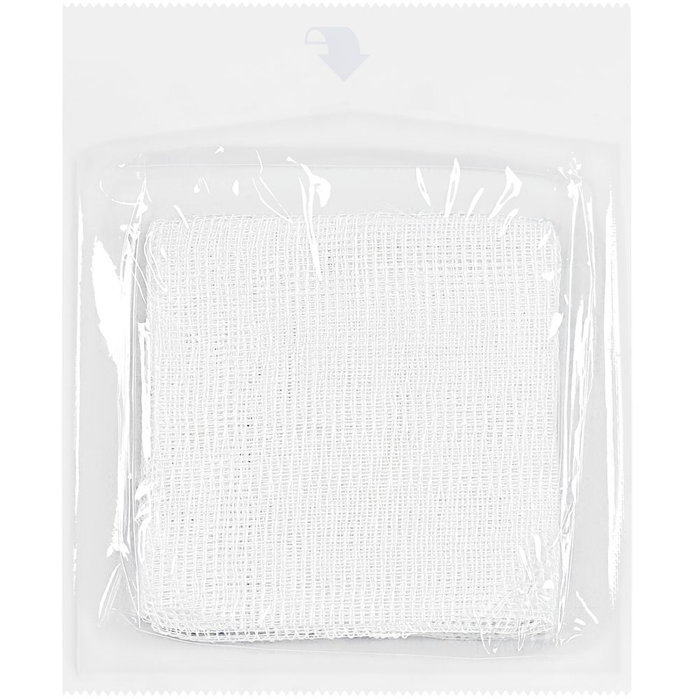 Singola compressa sterile in confezione trasparente. Forma quadrata. Struttura della garza visibile.