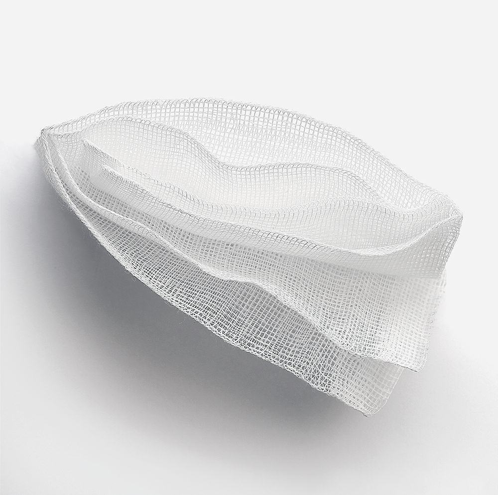 Diverse compresse di garza bianca, piegate. In cotone assorbente.