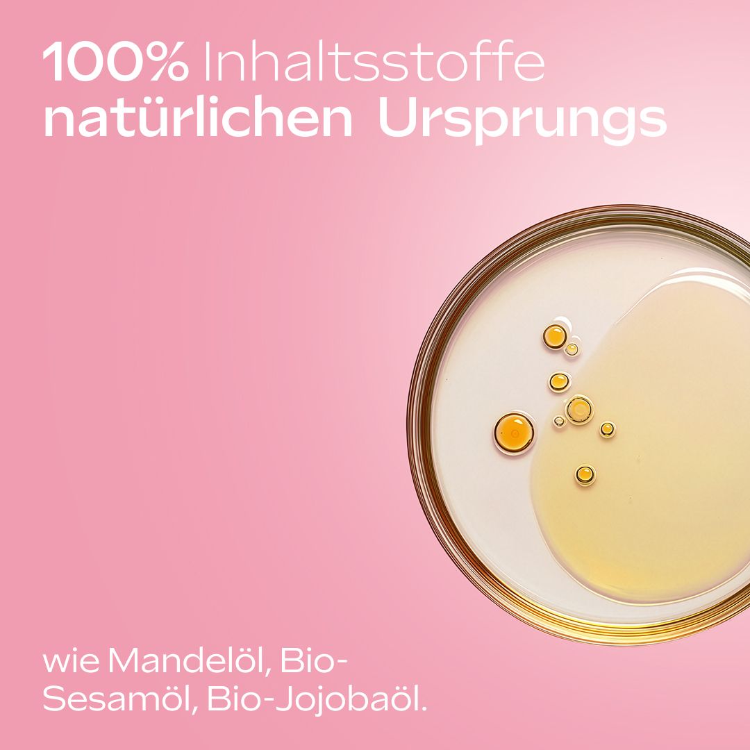 Primo piano dell'olio. Testo: 100% ingredienti di origine naturale. Olio di mandorle, olio di sesamo bio, olio di jojoba bio.