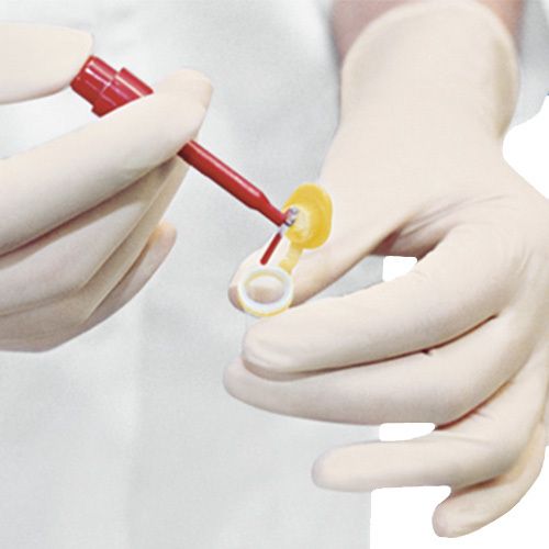 Mani con guanti tengono un dispositivo medico. Applicatore rosso.