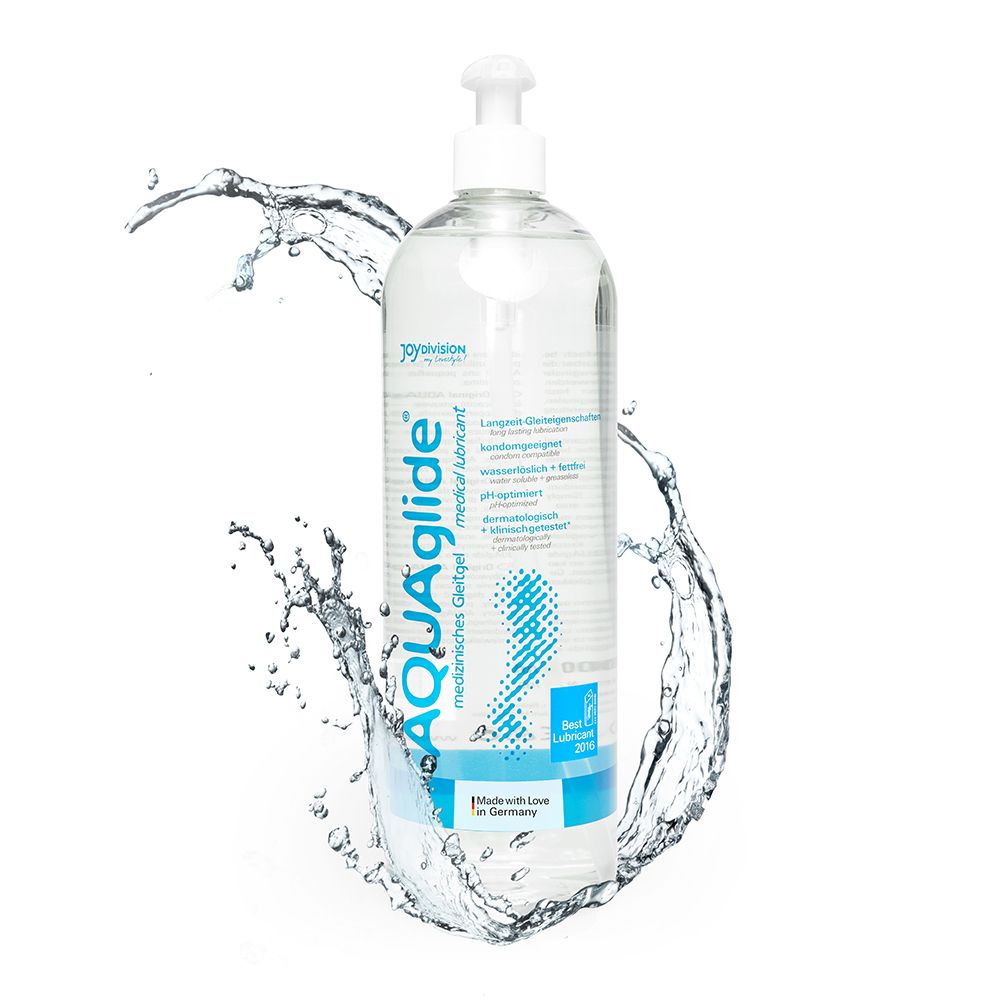 Flacone trasparente con dosatore bianco. Scritta AQUAglide, gel lubrificante medicale. L'acqua schizza intorno al flacone.