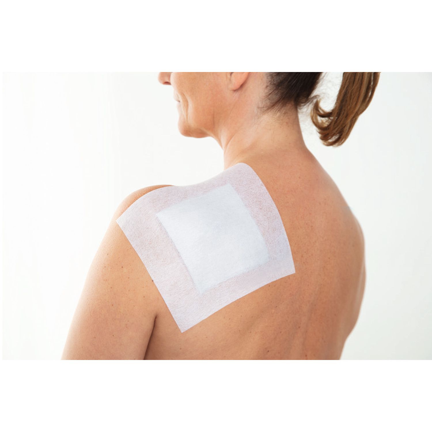 Fixomull® stretch sulla schiena. Mani con guanti. Bendaggio applicato.