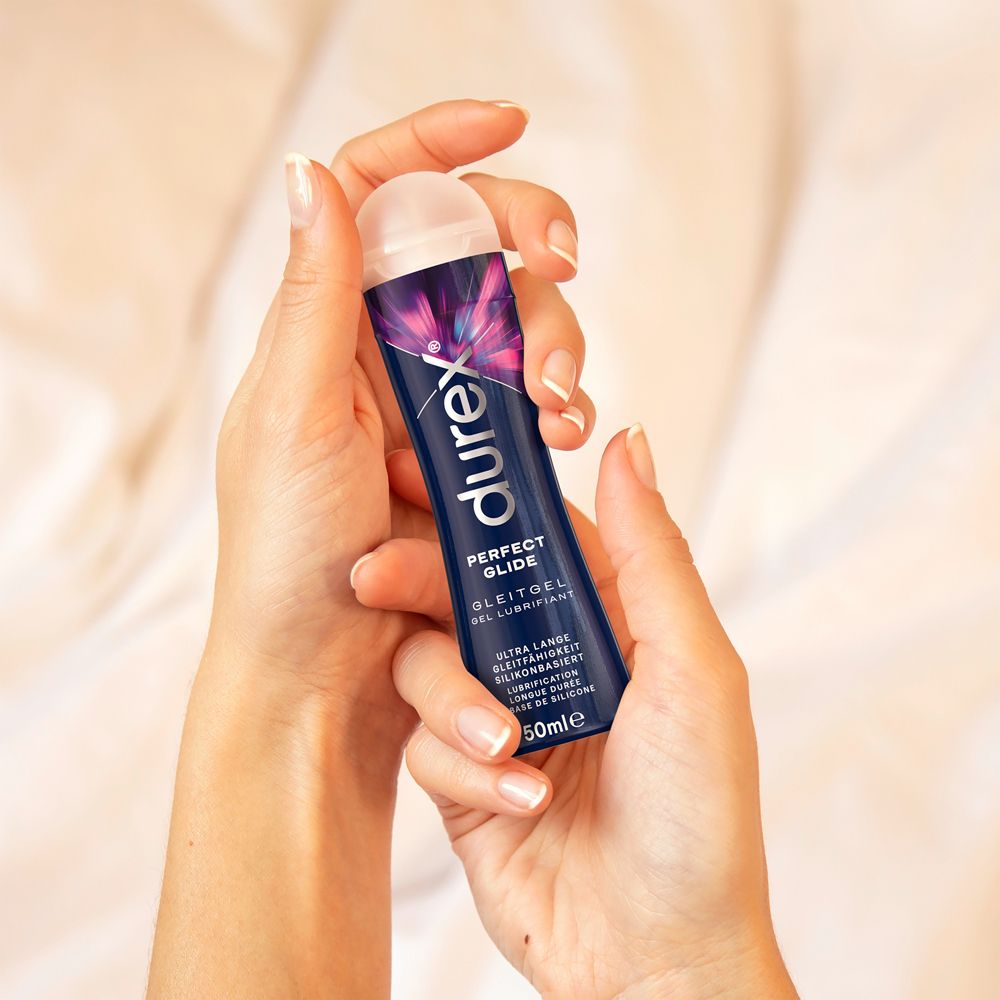 Mani che tengono un flacone di gel lubrificante Durex Perfect Glide.