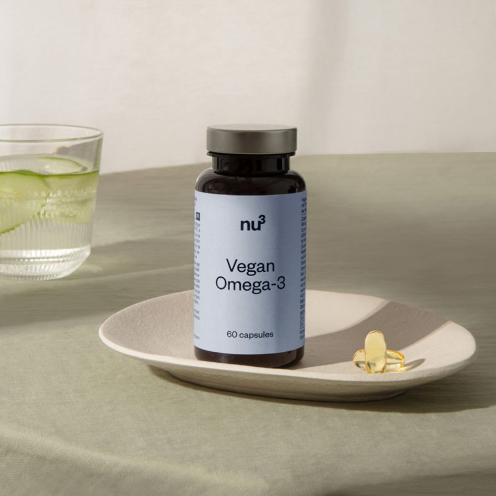 Una bottiglia con etichetta bianca e due capsule su un piatto. Scritta: nu3 Vegan Omega-3, 60 capsule.