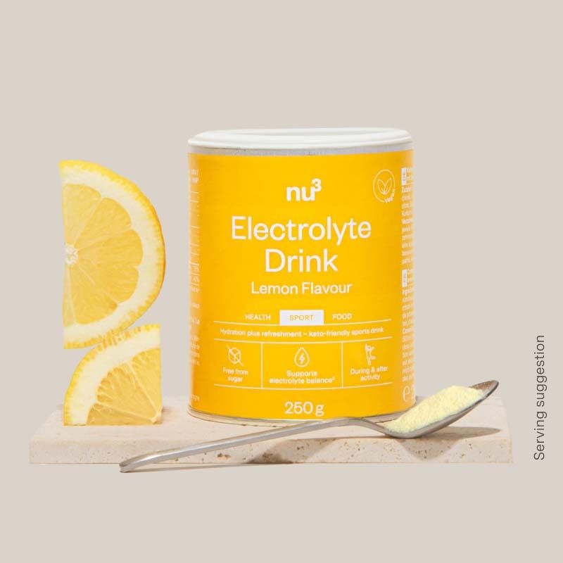 Lattina Nu3 Elektrolyte Drink con spicchi di limone e cucchiaio di polvere.
