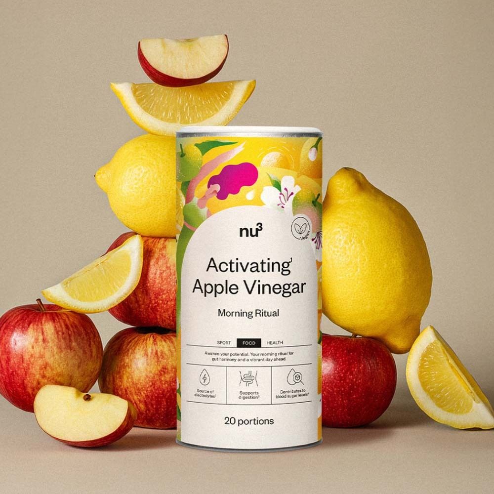 Barattolo "nu3 Activating Apple Vinegar" circondato da mele e limoni. Nome del prodotto e logo visibili. 20 porzioni.