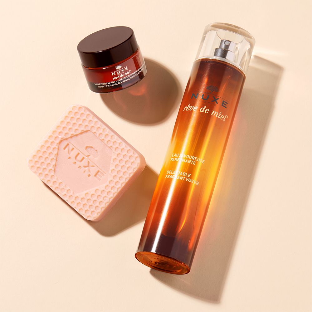 Tre prodotti: vasetto, sapone e flacone. Scritta: NUXE Rêve de Miel.