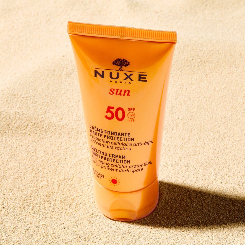 Tubo NUXE Sun crema solare SPF 50 sulla sabbia. Testo: Crème Fondante Haute Protection, Melting Cream High Protection.
