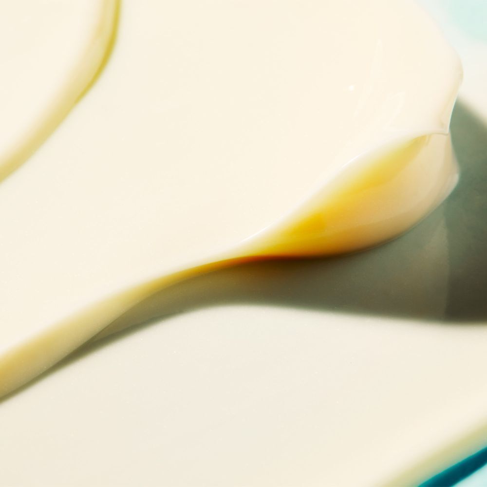 Primo piano di una crema bianca su una superficie chiara. Leggere ombre.