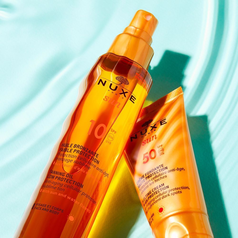 Olio solare e crema solare NUXE Sun. Flaconi e tubi arancioni con testo e fattore di protezione solare.