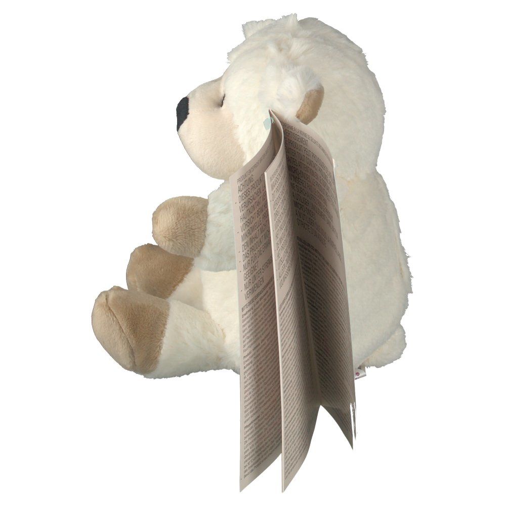 Pecora di peluche beige con brochure. Brochure parzialmente aperta. Prodotto di lato.