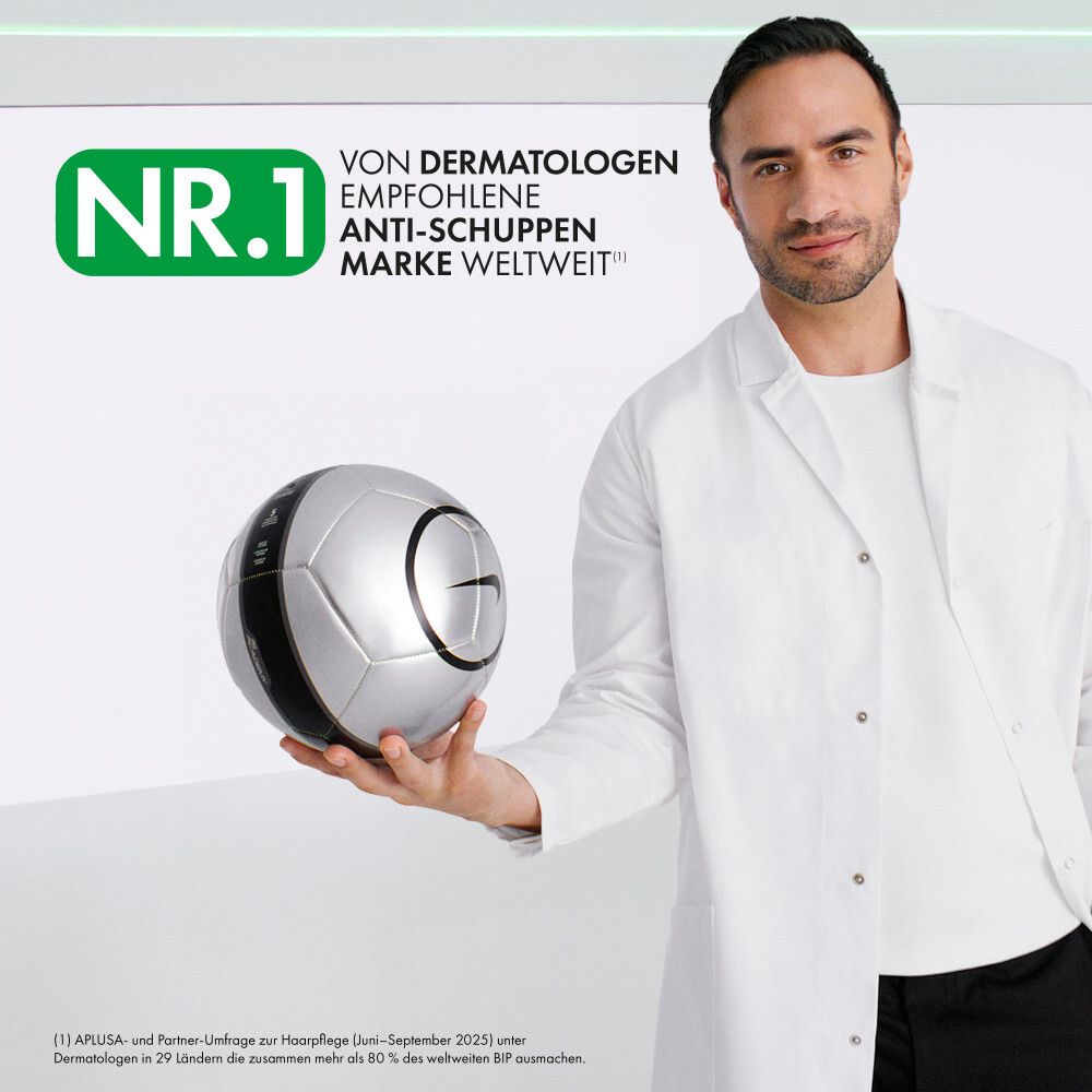 Uomo in camice bianco tiene pallone da calcio argentato con logo Nike nero.