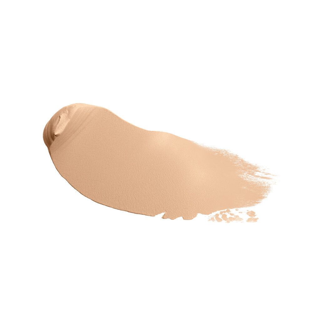 Una macchia cremosa di fondotinta color pelle su sfondo bianco.