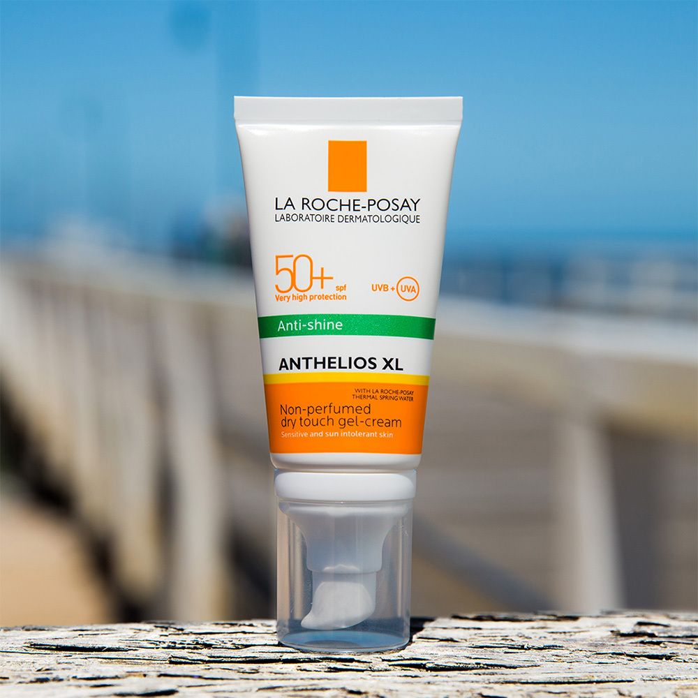 Tubo di crema solare, bianco, accenti arancioni e verdi. Testo: Anthelios XL 50+.