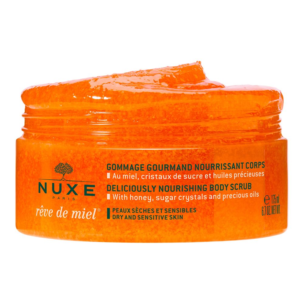 Vaso aperto NUXE Rêve de Miel® con scrub arancione visibile. Testo: Gommage Gourmand Nourrissant Corps, Deliciously Nourishing Body Scrub.
