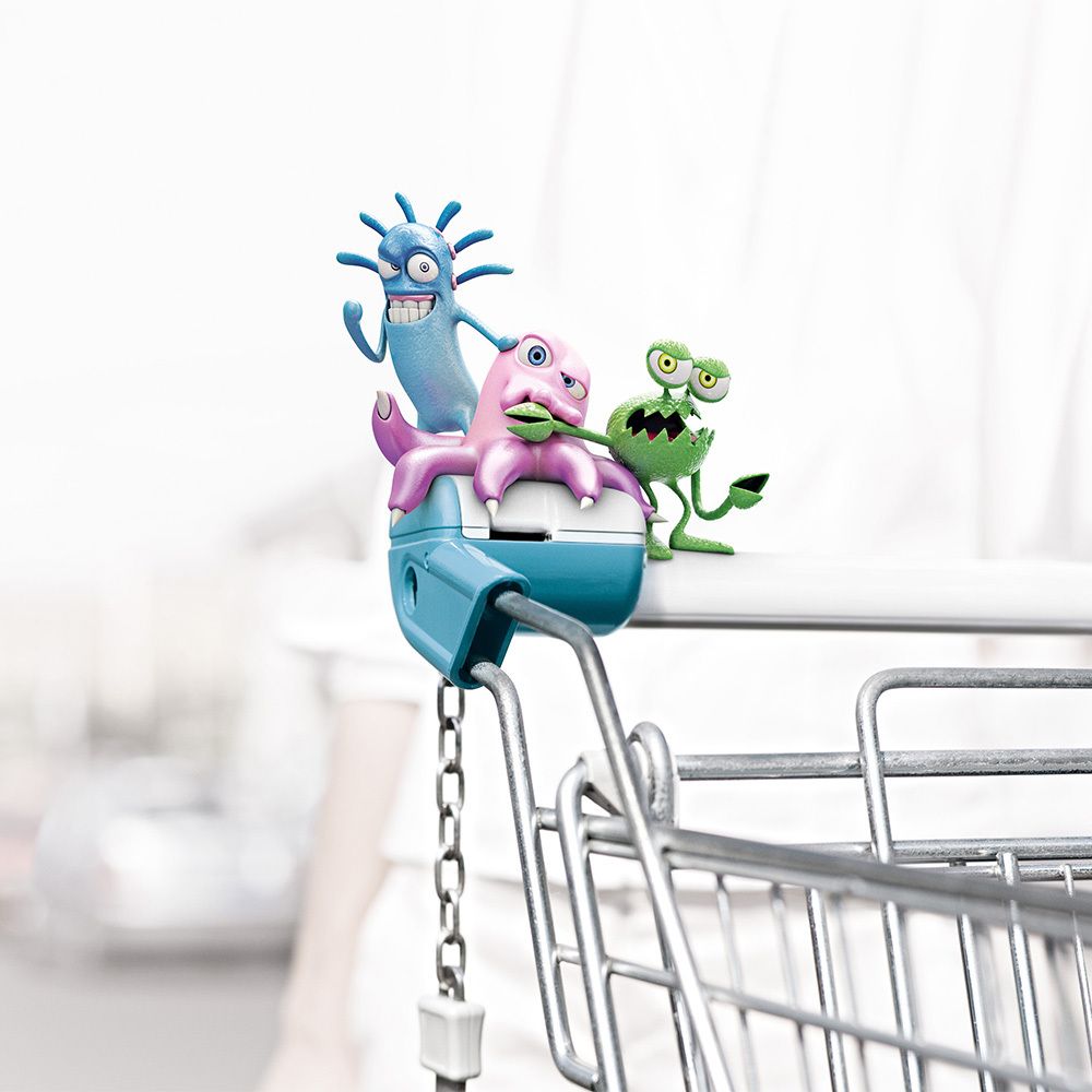 Tre germi dei cartoni animati su un carrello della spesa. Uno è blu, uno rosa, uno verde.