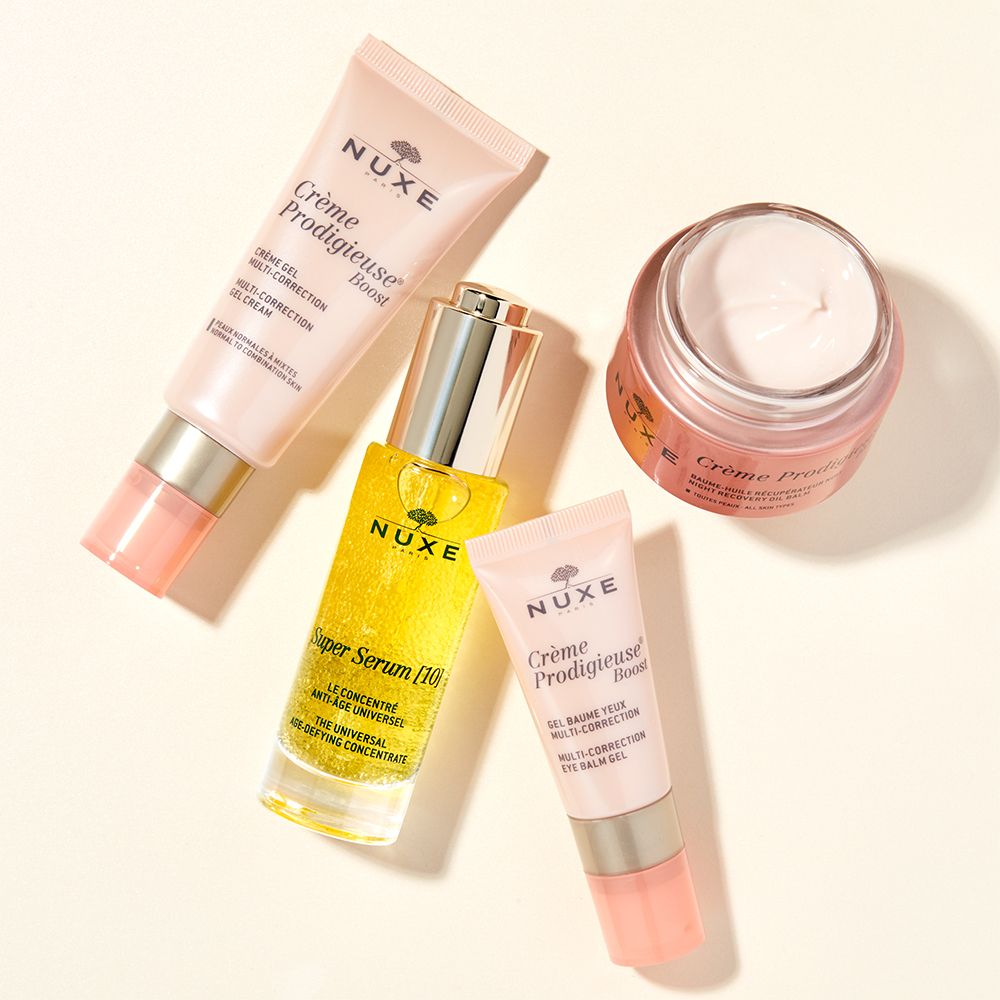 Vari prodotti NUXE: Crème Prodigieuse® Boost, Super Siero [10] e balsamo occhi. Contenitori rosa, gialli e trasparenti.