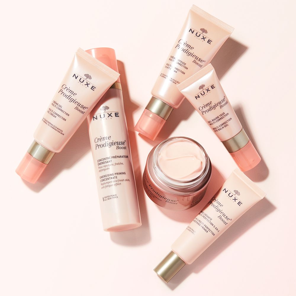 Vari prodotti NUXE: Crème Prodigieuse® Boost, concentrato e crema occhi. Contenitori rosa e trasparenti.