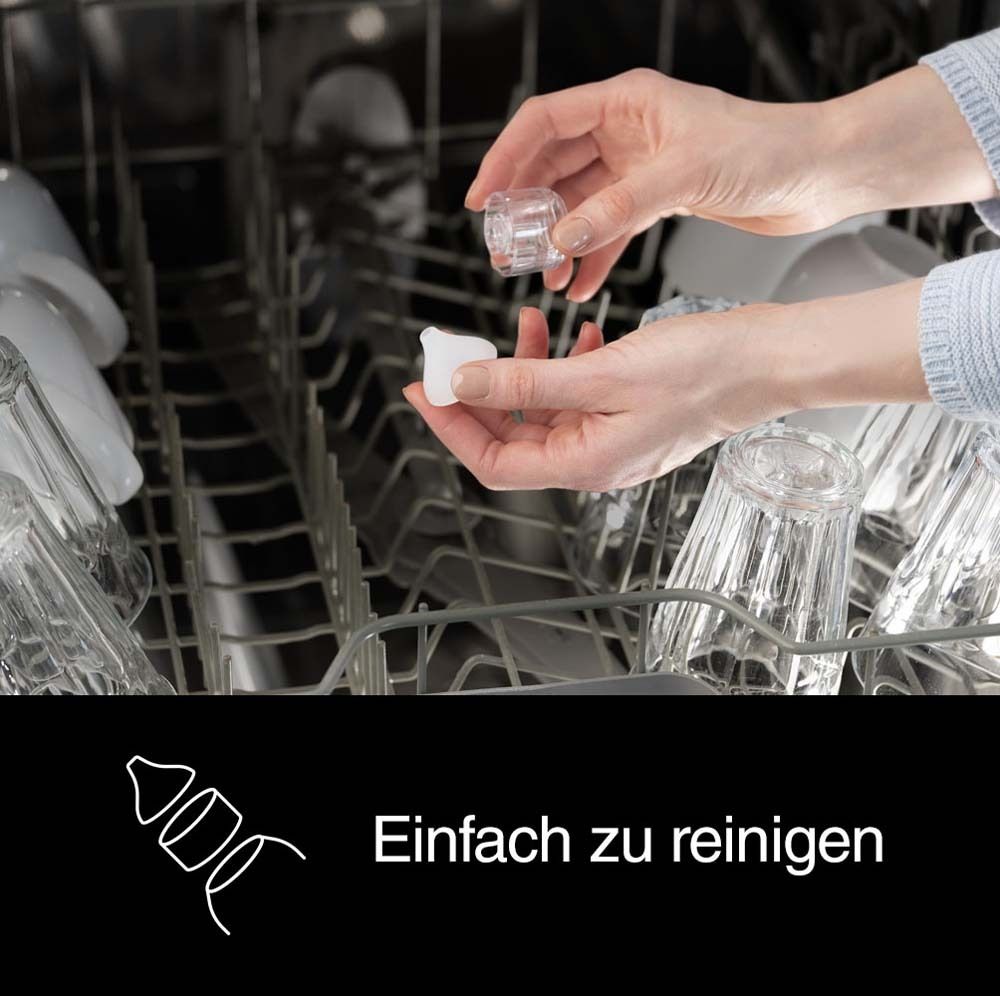 Mani tengono parti dell'aspiratore nasale sopra lavastoviglie. Testo: Facile da pulire.