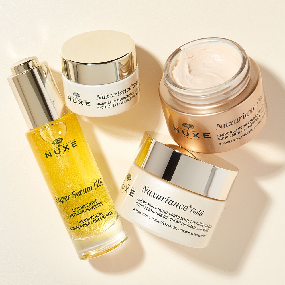 Prodotti cosmetici: siero, crema occhi e due vasetti Nuxuriance Gold.