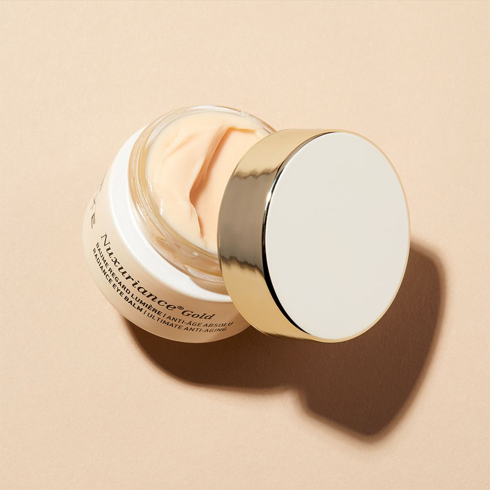 NUXE Nuxuriance Gold contorno occhi. Vasetto aperto, coperchio dorato. Crema visibile. Testo: Nuxuriance Gold.