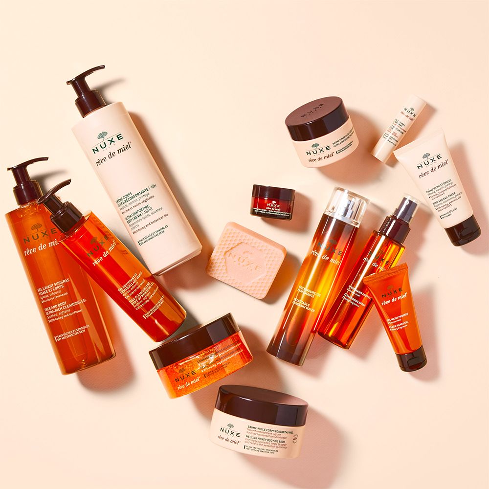 Vari prodotti cosmetici. Scritta: NUXE, Rêve de Miel. Flaconi, vasetti, vasetti di crema.