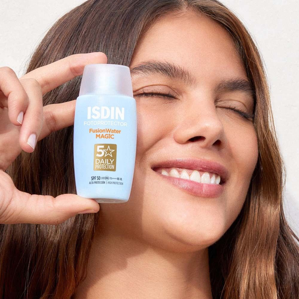 Donna tiene ISDIN Fusion Water Magic. Flacone blu, tappo bianco. Viso con occhi chiusi.