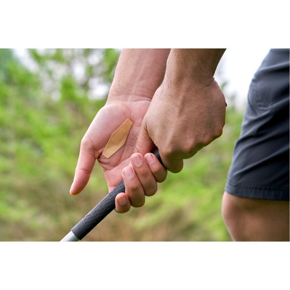 Cerotto beige con parte centrale bianca. Freccia che indica la direzione.