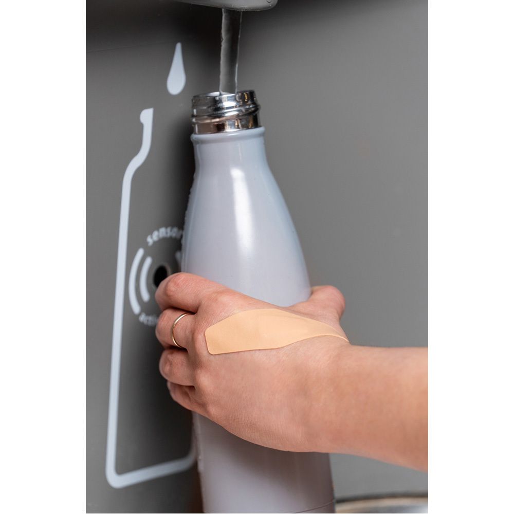 Mano con cerotti sulle dita. Manubrio sullo sfondo. Cerotti beige.