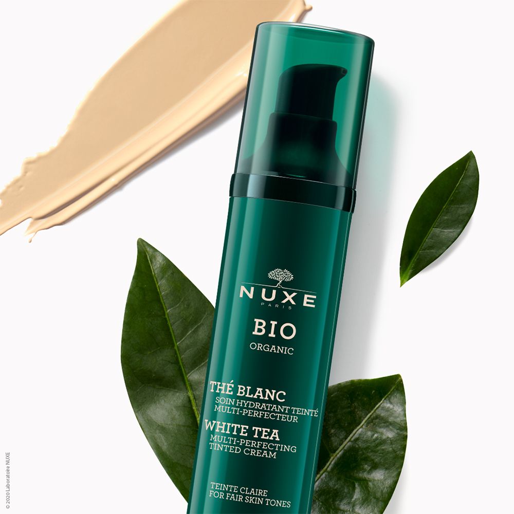 Flacone verde con dosatore, accanto una macchia di colore e foglie. Scritta: NUXE BIO, Thé Blanc.