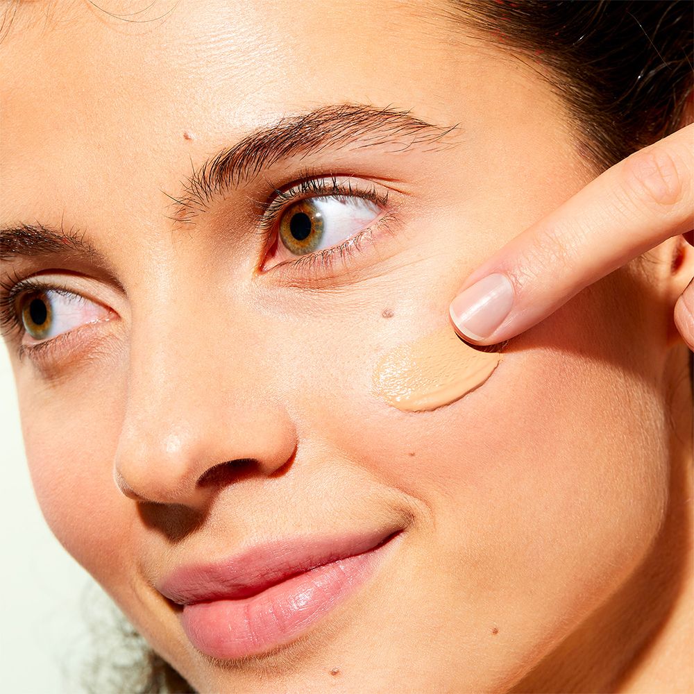 Donna applica crema colorata. Tonalità chiara.