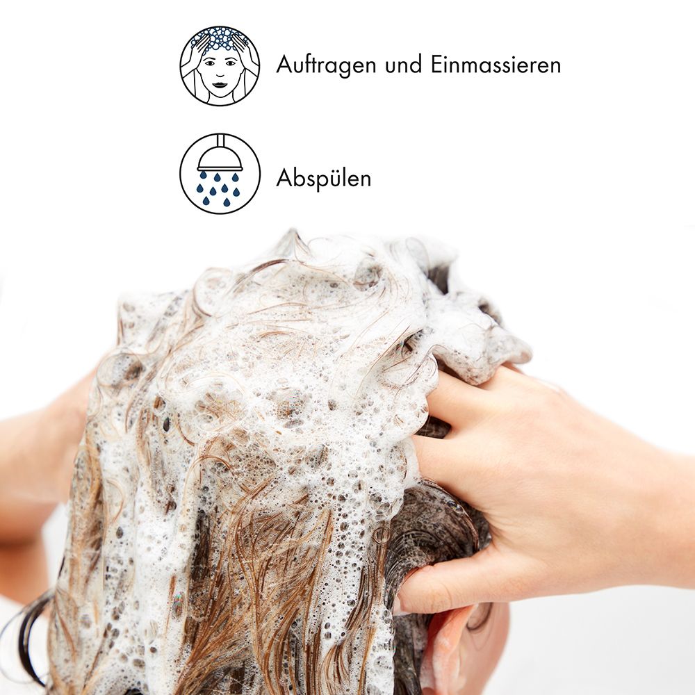 Persona massaggia shampoo schiumoso nei capelli.