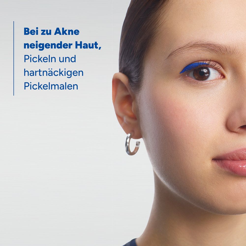 Primo piano di una donna con eyeliner blu e orecchini d'argento. Testo: Per pelli a tendenza acneica, brufoli e segni persistenti.