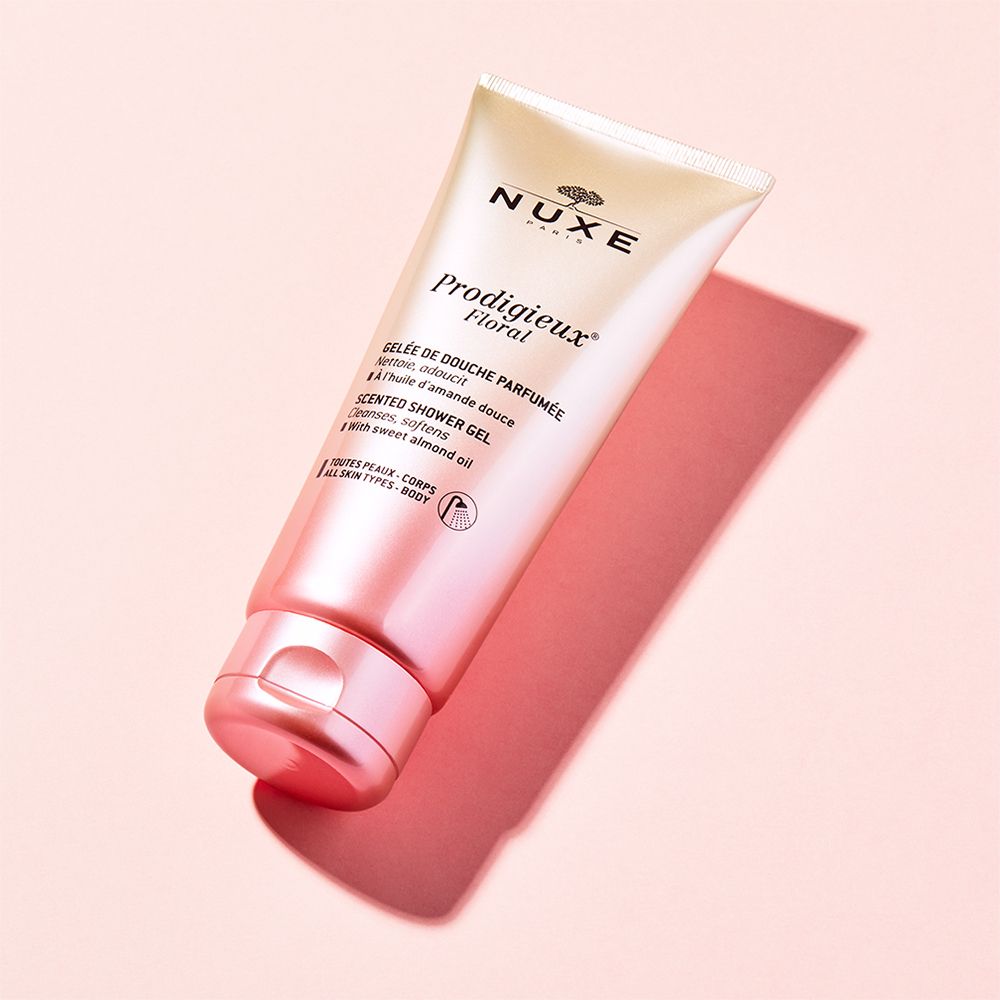 Gel doccia NUXE Prodigieux Floral. Tubo sfumato rosa. Nome e marchio visibili. Ombra.