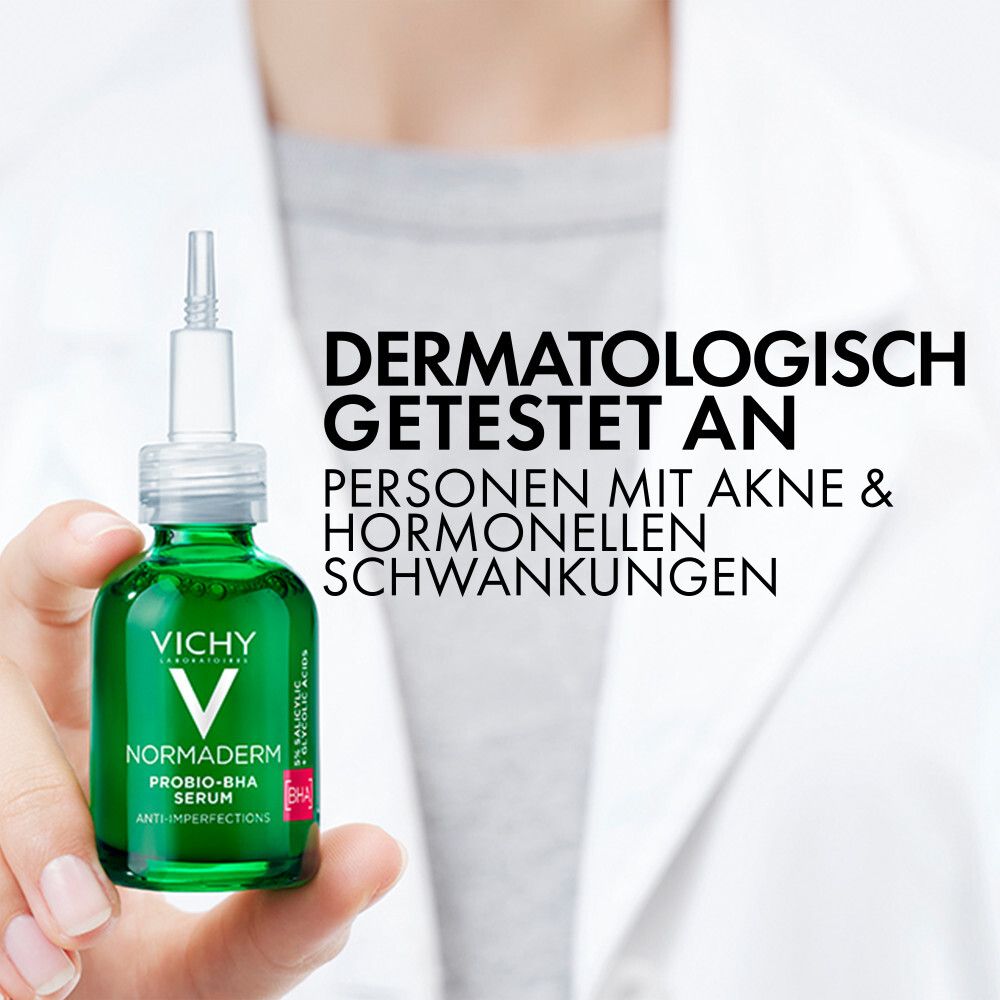 Flacone di siero in mano. Testo: Testato dermatologicamente su persone con acne e fluttuazioni ormonali.