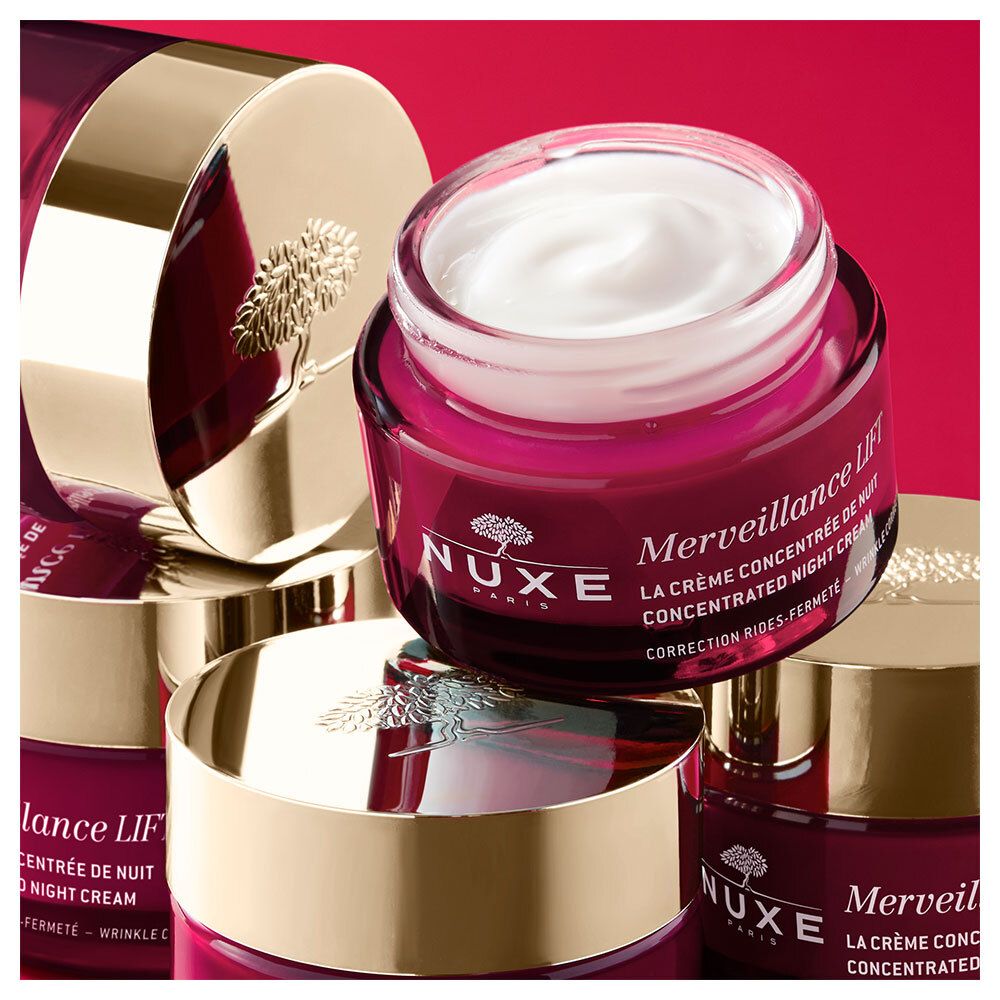 Diversi vasi rossi con coperchi dorati. Un vaso è aperto e mostra la crema. Scritta: Merveillance Lift, NUXE.