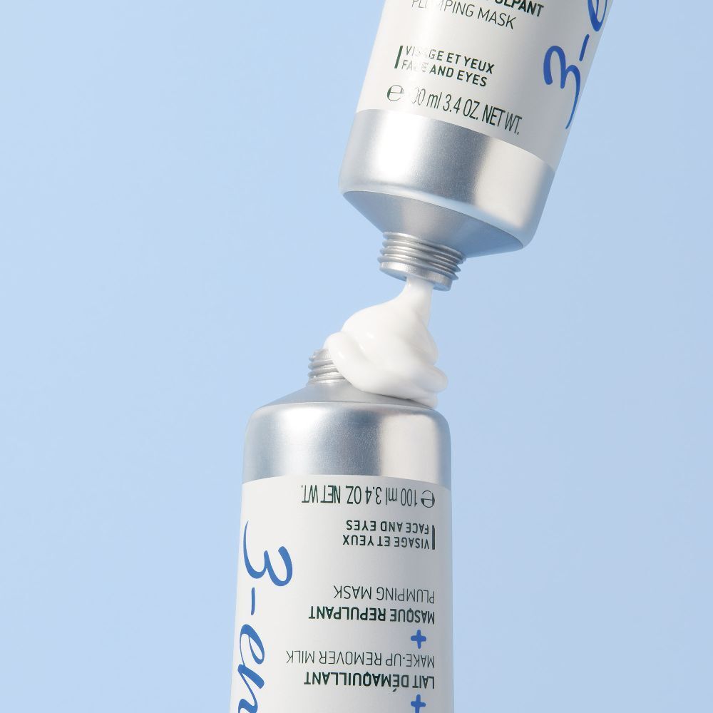 Tubo di Crème Fraîche de Beauté. La crema viene spremuta dal tubo. Sfondo blu.