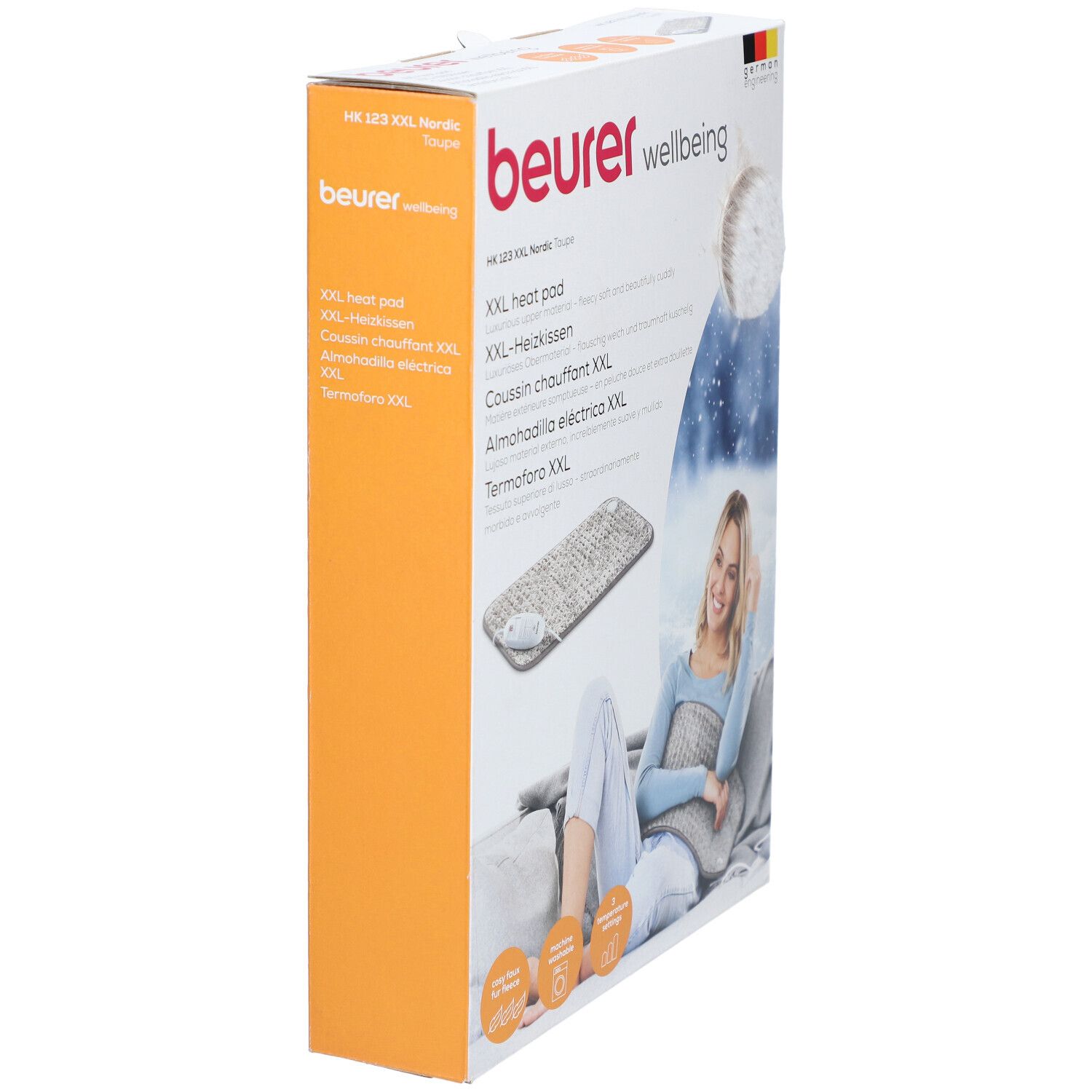 Confezione del prodotto. Cuscino riscaldante Beurer HK 123 XXL Nordic. Vista laterale. Testo: Beurer, Wellbeing, German Engineering. Sfondo arancione.