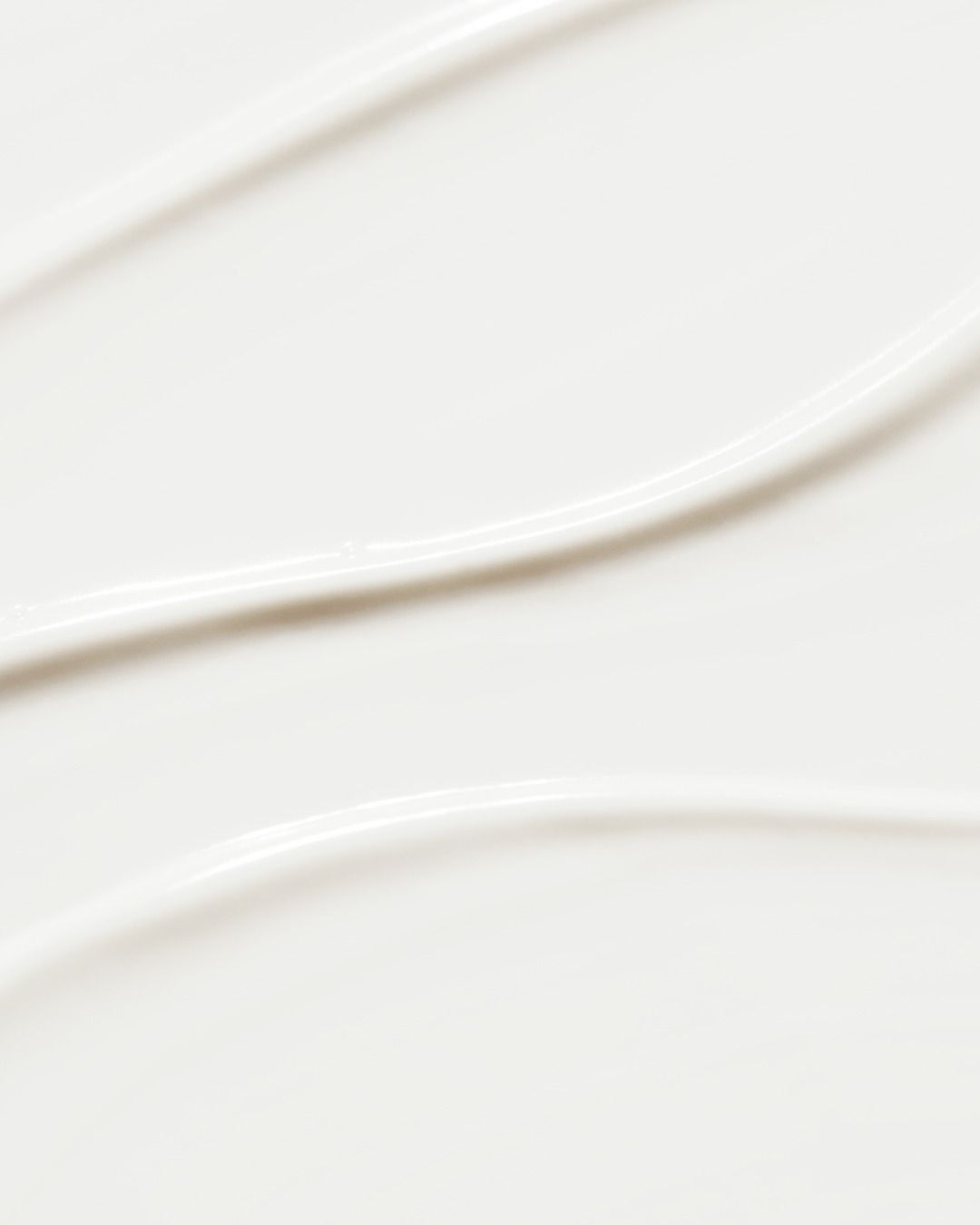 Primo piano di crema bianca. Texture liscia con tre linee parallele.