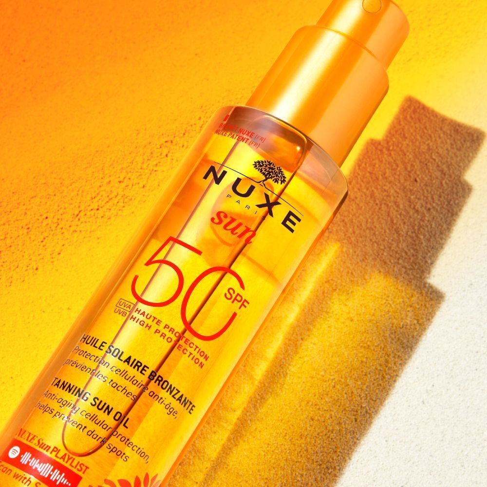 Primo piano del flacone di olio solare Nuxe Sun SPF 50, alla luce del sole.