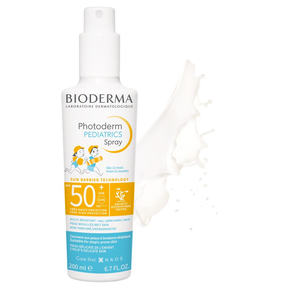 BIODERMA Photoderm PEDIATRICS Spray 50+. Flacone bianco con erogatore spray. Etichetta giallo-blu. Schizzo bianco sullo sfondo.