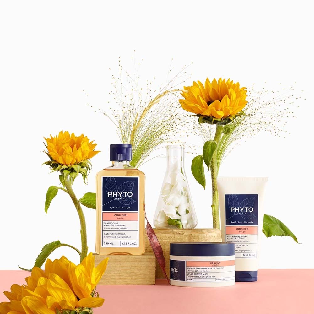 Prodotti per capelli Phyto: flacone, tubo e vasetto con girasoli.