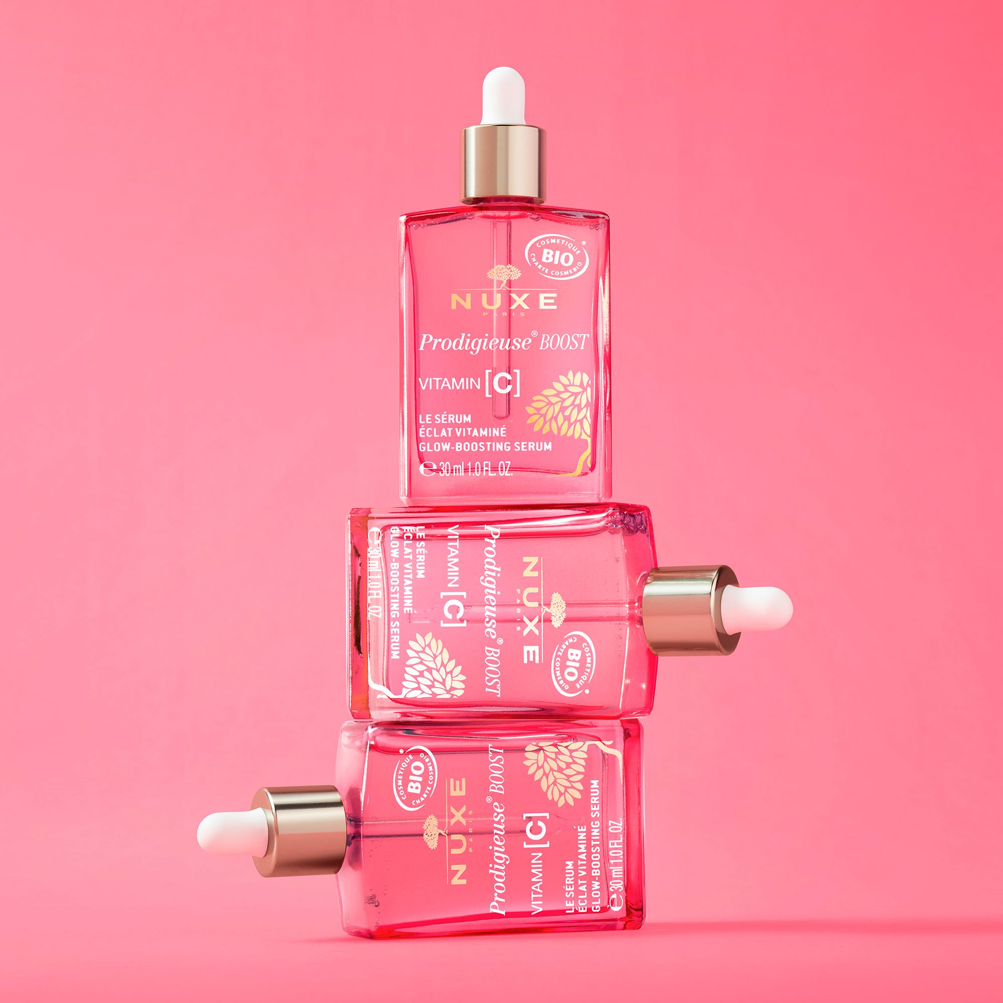 Tre flaconi di siero rosa. Scritta: NUXE Prodigieuse Boost Vitamina C.
