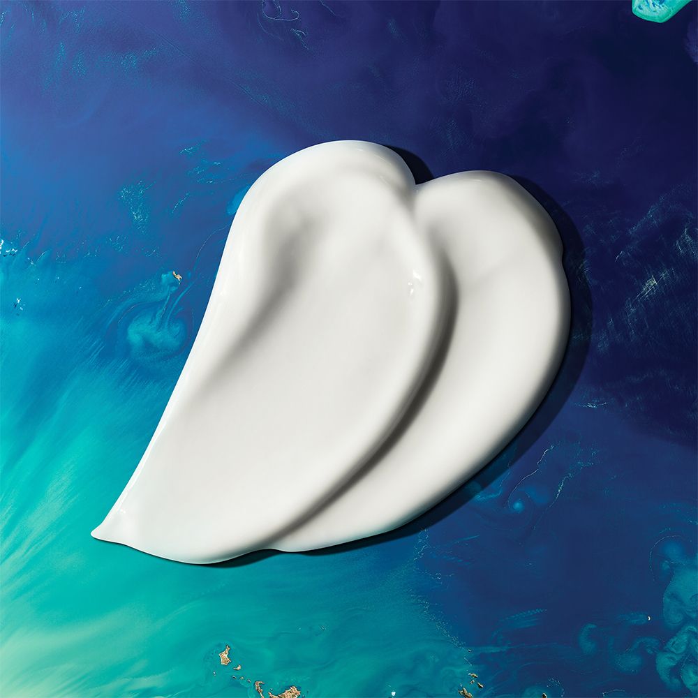 Due strisce di crema solare bianca su sfondo blu. Forma: cuore.